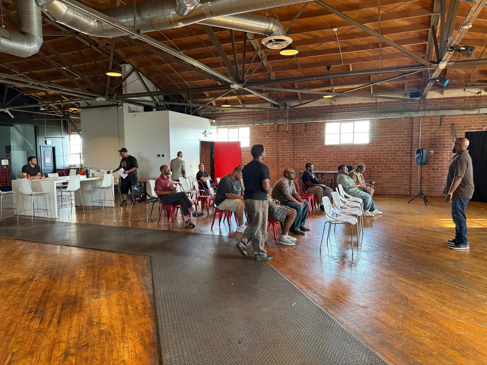 Men gathered in a circle of chairs for an Adam Project meeting